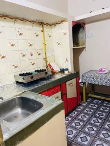 a dirty kitchen with a sink and a counter at Shree Avantika home stay in Ujjain