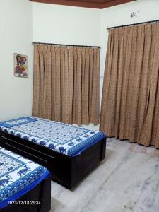 two twin beds in a room with curtains at Gokulam Villa in Udaipur