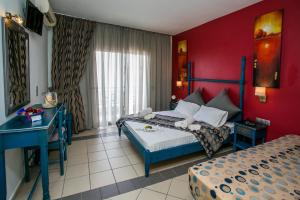 a bedroom with two beds and a red wall at Thalassies in Limenaria