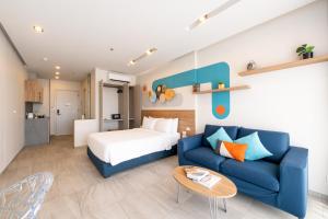 um quarto com uma cama e um sofá azul em HOMA Phuket Town em Cidade Phuket