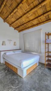 a large white bed in a room with a wooden ceiling at Mancora Soul in Máncora