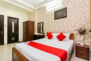 um quarto com uma cama grande e almofadas vermelhas em Hoàng Yến Nhi Hotel - 36 Đ. Số 51, Gò Vấp - by Bay Luxury em Ho Chi Minh