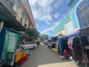 巴淡島中心的住宿－SPOT ON 93446 Penginapan Mak Yes，一条街道上设有装满衣服的市场和一辆汽车