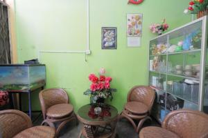 巴淡島中心的住宿－SPOT ON 93446 Penginapan Mak Yes，一间设有椅子和一张花瓶桌子的房间