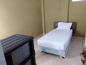 Säng eller sängar i ett rum på SPOT ON 93464 Penginapan Tulimario Syariah
