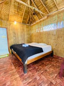 a bedroom with a bed in a bamboo wall at Adhya Home Stay Hampi in New Hampi