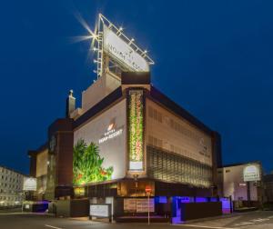 a building with a sign on top of it at night at Hotel Noah Resort Sakuranomiya (Adult Only) in Osaka