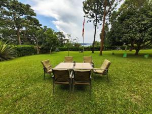 a table and chairs sitting in the grass at Vacation Home with Lake view in Kampala