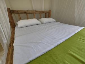 a bed with two pillows on it in a room at Vacation Home with Lake view in Kampala