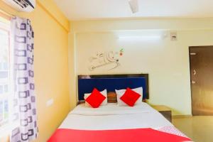 1 dormitorio con 1 cama con almohadas rojas y blancas en Hotel Retreat ! Puri, en Puri