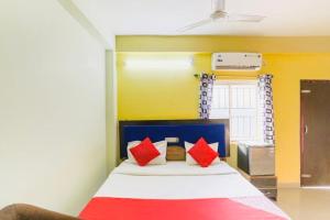 1 dormitorio con 1 cama con almohadas rojas y azules en Hotel Retreat ! Puri, en Puri