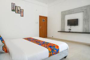 a white room with a bed and a tv at FabHotel Irra Executive in Pune