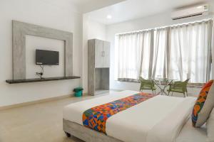 a bedroom with a bed and a table and a tv at FabHotel Irra Executive in Pune