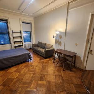 紐約的住宿－New York City Guest House 2，一间卧室配有一张床、一张桌子和一张沙发