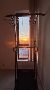 a window in a room with a view of the sunset at Fully furnished Studio Unit. in Sungai Buluh