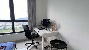 a bedroom with a desk with a computer and two chairs at Fully furnished Studio Unit. in Sungai Buluh