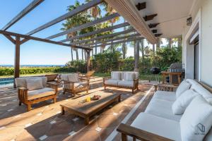 マルベーリャにあるSpacious 6 BDRM Villa - Golf Lover's Paradiseのパティオ(ソファ、椅子、テーブル付)