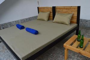 a bed with two blue pillows and a table at Guacamayas Resort Vacation in La Mesa