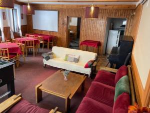 a living room with a couch and tables and chairs at Chata Barbora in Lučany nad Nisou