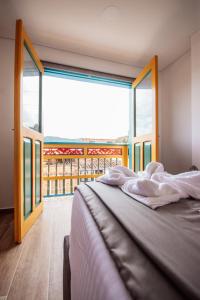 a bed in a room with a large window at Las Palmas Apartamentos Guatapé in Guatapé