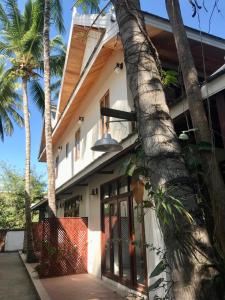 a house with palm trees in front of it at Luangprabang Villa bouathong Hotel in Luang Prabang
