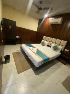 Hotel Mannat International at Paschim Vihar في نيودلهي: غرفة نوم بسرير كبير في غرفة