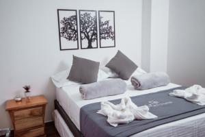 1 dormitorio con 1 cama con toallas en Las Palmas Apartamentos Guatapé, en Guatapé