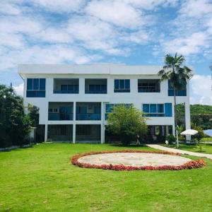 duży biały budynek z dużym ogrodem przed nim w obiekcie Montañita, Condominio La Aurora, Departamento #6 w mieście Montañita