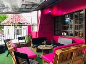 une terrasse avec des meubles roses, une table et des chaises dans l'établissement Habitacion en La Vie en Rose, à Carthagène des Indes