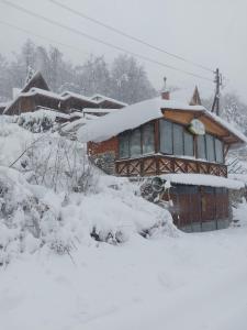 a house covered in snow in front at Vila Jana Mavrovo in Mavrovo
