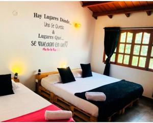 a bedroom with two beds and a writing on the wall at Habitacion en La Vie en Rose in Cartagena de Indias