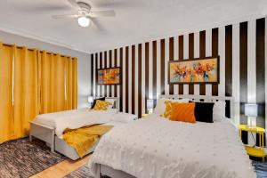 um quarto com 2 camas e uma parede listrada em Groovy Winter Haven Getaway - 4 bdrm near Legoland em Winter Haven