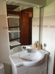 La salle de bains est pourvue d'un lavabo blanc et d'un miroir. dans l'établissement Maison&jardin charmant&typique au cœur du Conflent, à Sahorre