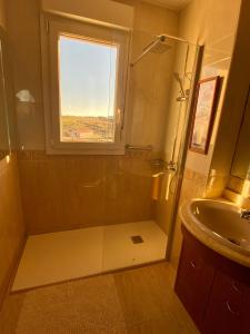 een badkamer met een douche, een wastafel en een raam bij El Rincón del Marqués in Las Navas del Marqués