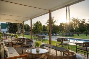 een patio met tafels en stoelen en een zwembad bij Protea Hotel by Marriott George King George in George