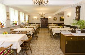 un restaurant avec des tables et des chaises et un lustre dans l'établissement Hotel Rosner, à Gablitz