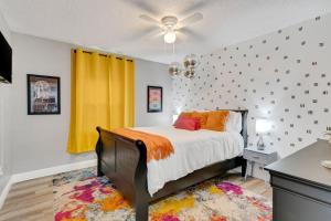 a bedroom with a bed and a yellow curtain at Groovy Winter Haven Getaway - 4 bdrm near Legoland in Winter Haven