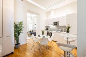 eine Küche und ein Wohnzimmer mit einem Tisch und Stühlen in der Unterkunft Luxury Quentin Apartment 3 BEDRM, 2 BATHRM in Budapest