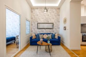 uma sala de estar com um sofá azul e uma mesa em Luxury Quentin Apartment 3 BEDRM, 2 BATHRM em Budapeste