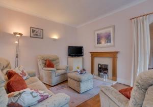a living room with two chairs and a fireplace at Mews Cottage in Scarborough