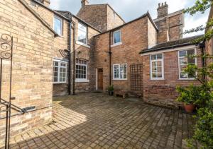 an exterior view of a brick house with a courtyard at Mews Cottage in Scarborough