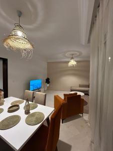 a dining room with a white table and chairs at formidable S2 près du carrefour in La Marsa