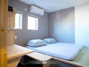 鎌倉市にある北鎌倉520のベッド1台と枕2つが備わる小さな客室です。