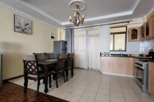 a kitchen and dining room with a table and chairs at Lovely Modern 2- bedroom apartment in Upperhill in Nairobi