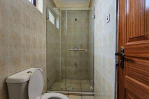 a bathroom with a shower with a toilet and a glass door at Lovely Modern 2- bedroom apartment in Upperhill in Nairobi