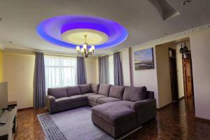 a living room with a couch and a blue ceiling at Lovely Modern 2- bedroom apartment in Upperhill in Nairobi