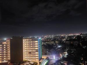 a city skyline at night with a tall building at Lovely Modern 2- bedroom apartment in Upperhill in Nairobi