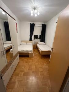 Cette petite chambre comprend 2 lits et un miroir. dans l'établissement Apartment Dolina 8a Kärnten KLagenfurt, 