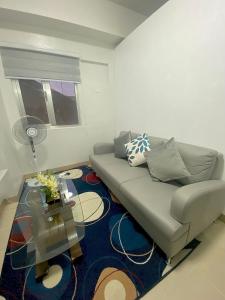 a living room with a couch and a table at Condotel - Minimalistic 2 minutes walk to SM Marilao in Marilao