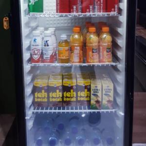 a refrigerator filled with lots of drinks and milk at Capital Hotel Makassar in Pampang